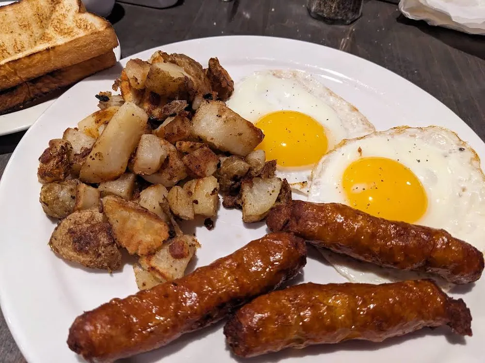 Two eggs with sausages and home fries